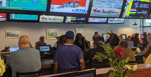 Black Eyed Susan Lansing sports betting area with customers watching racing on multiple screens